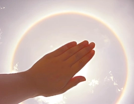 Eine Hand gibt nach unten lichtvolle Energie ab und veranschaulicht das energetische Heilen durch Handauflegen.